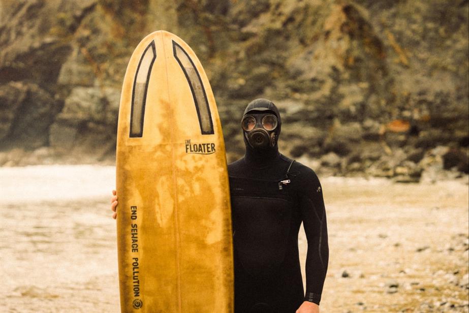 Surfer standing with Floater surfboard