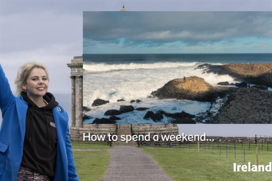 Actress Saoirse-Monica Jackson stands in front of a billboard of the Irish coast with the caption "How to spend a weekend"
